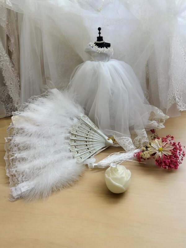 Elegifta Wedding Gift Set featuring an elegant mini wedding dress, sophisticated feather hand fan, beautiful guest book for memories, luxurious silk rose pillow cases, stylish hair tie, whimsical satan eye mask, serene white flower candle, meaningful wedding heart message, charming mini bouquet, and fragrant natural rose soap.