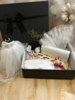 Elegifta Wedding Gift Set featuring an elegant mini wedding dress, sophisticated feather hand fan, beautiful guest book for memories, luxurious silk rose pillow cases, stylish hair tie, whimsical satan eye mask, serene white flower candle, meaningful wedding heart message, charming mini bouquet, and fragrant natural rose soap.