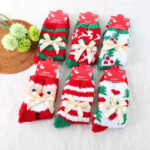 Christmas-themed fluffy socks with festive patterns, tied with elegant ribbon bows, in red, green, and white colors.